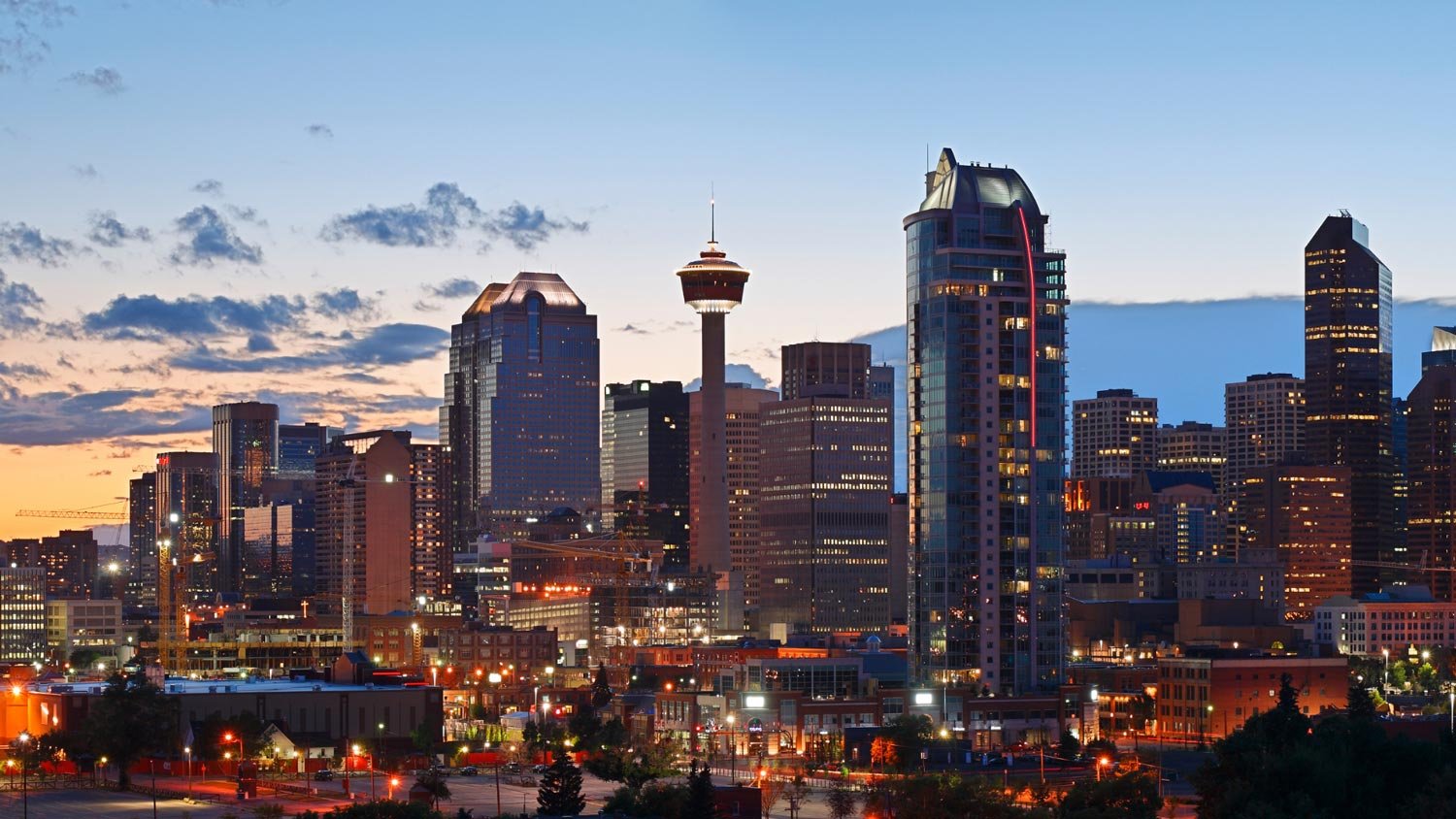 A view of Calgary's skyline at dusk with a prominent view of the Calgary Tower.