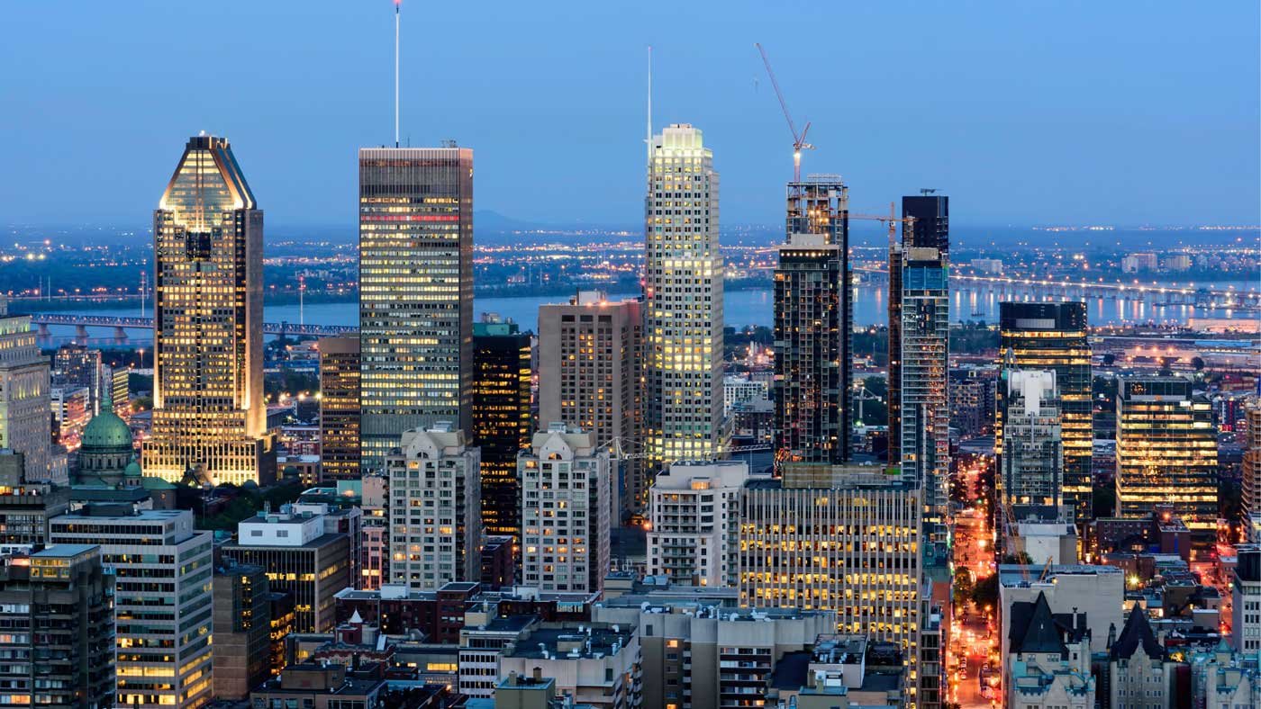A panoramic view of Montreal's skyline illuminated at night.