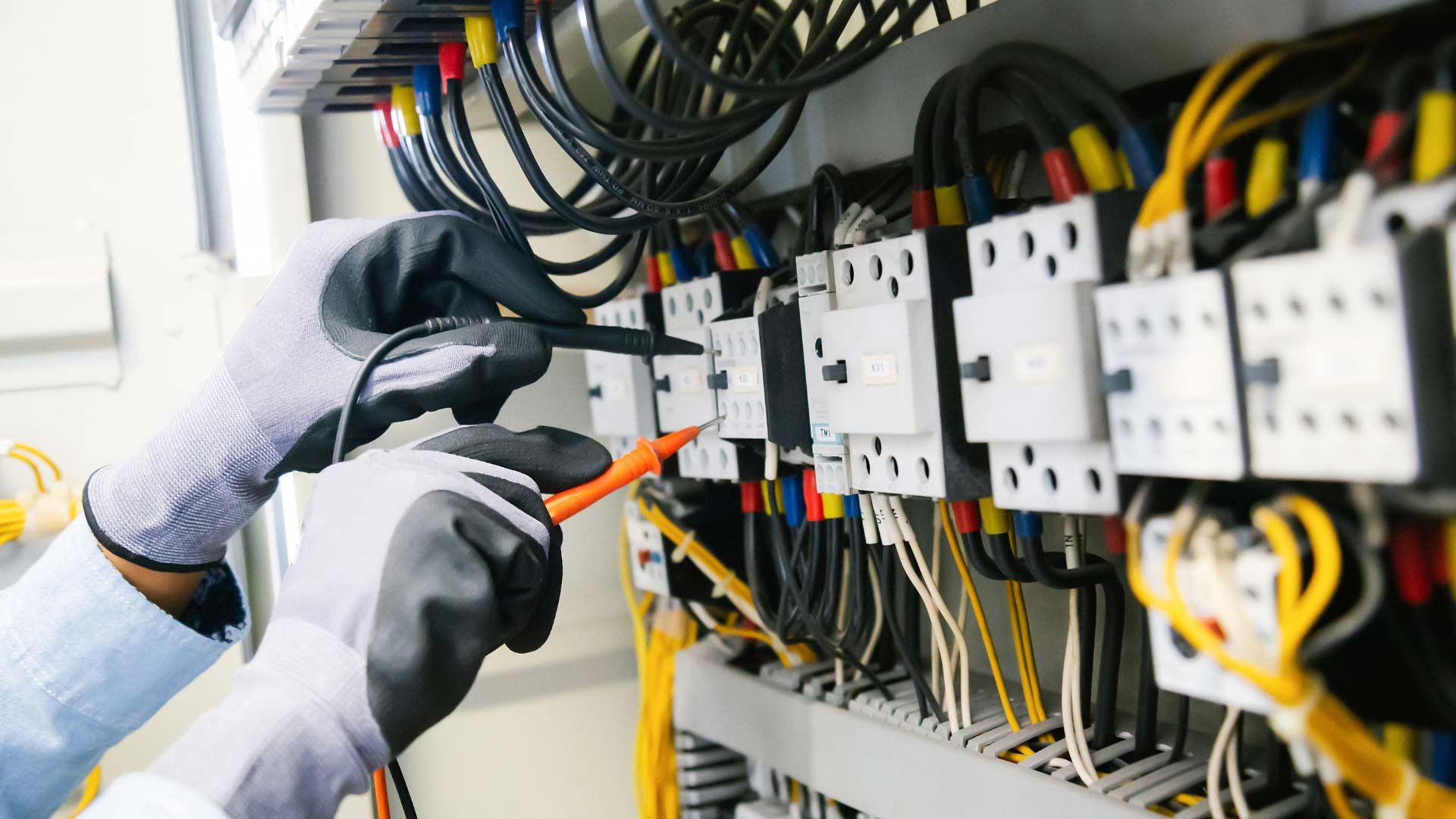 An electrician adjusting complex electrical components in a panel