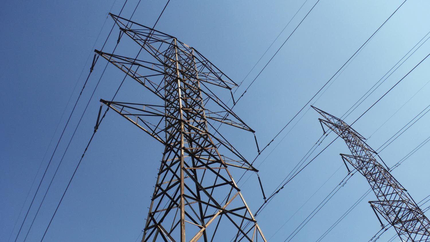 High voltage power lines against a clear sky