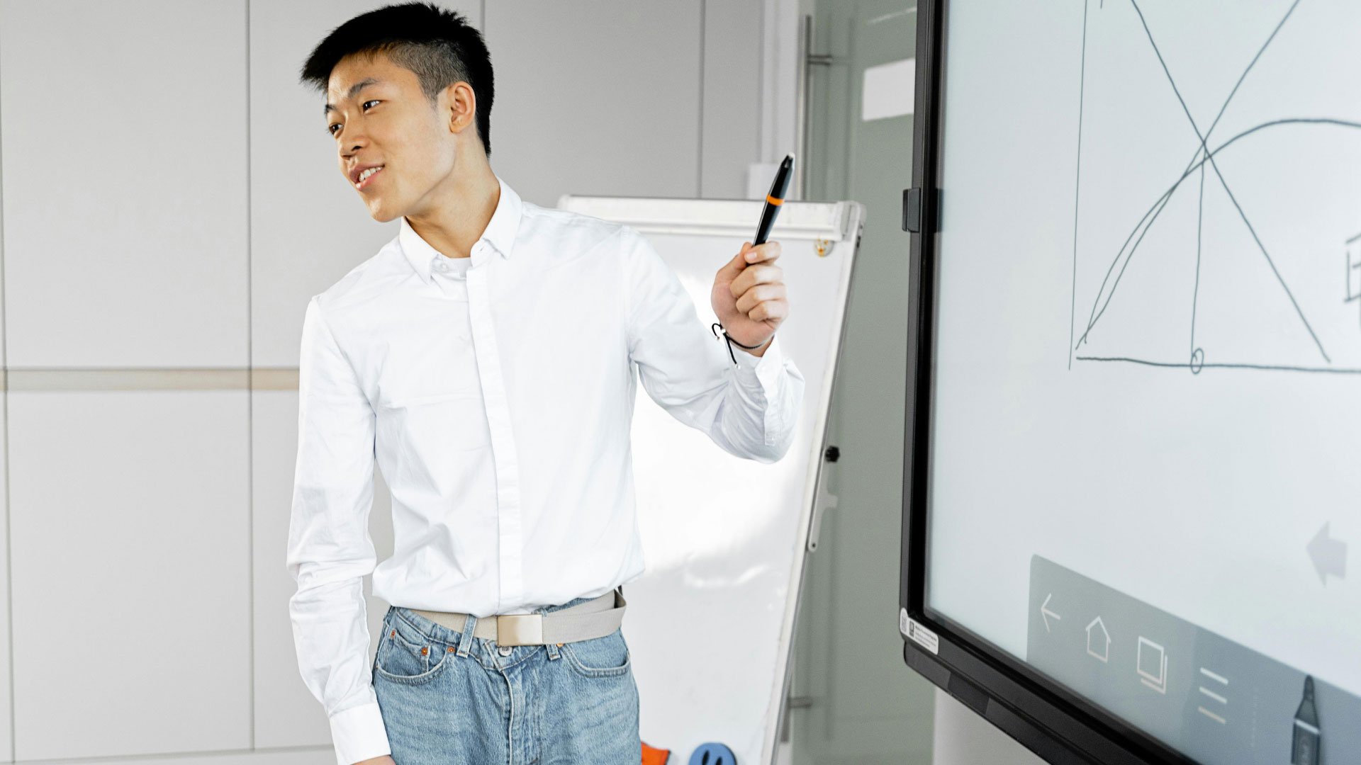 A businessman giving a presentation using a whiteboard in a modern office setting