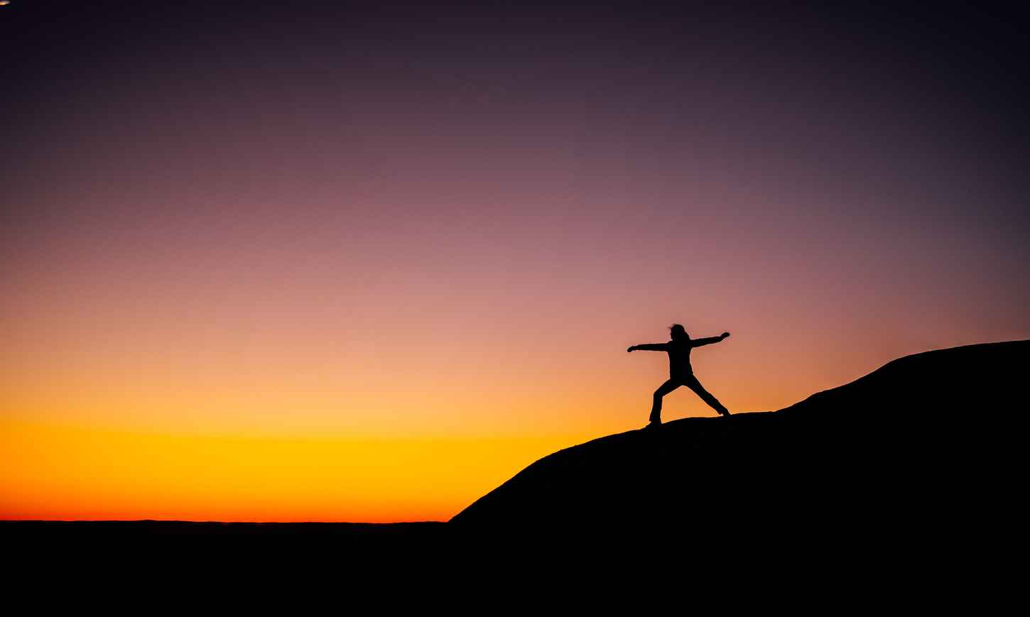 Woman doing yoga at sunset