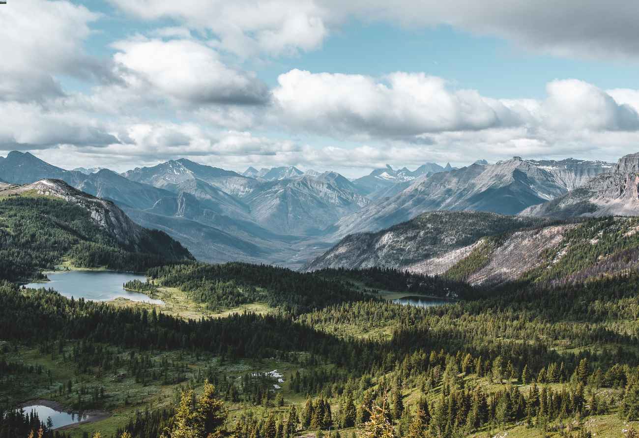 A lush mountain range with clouds in the sky.