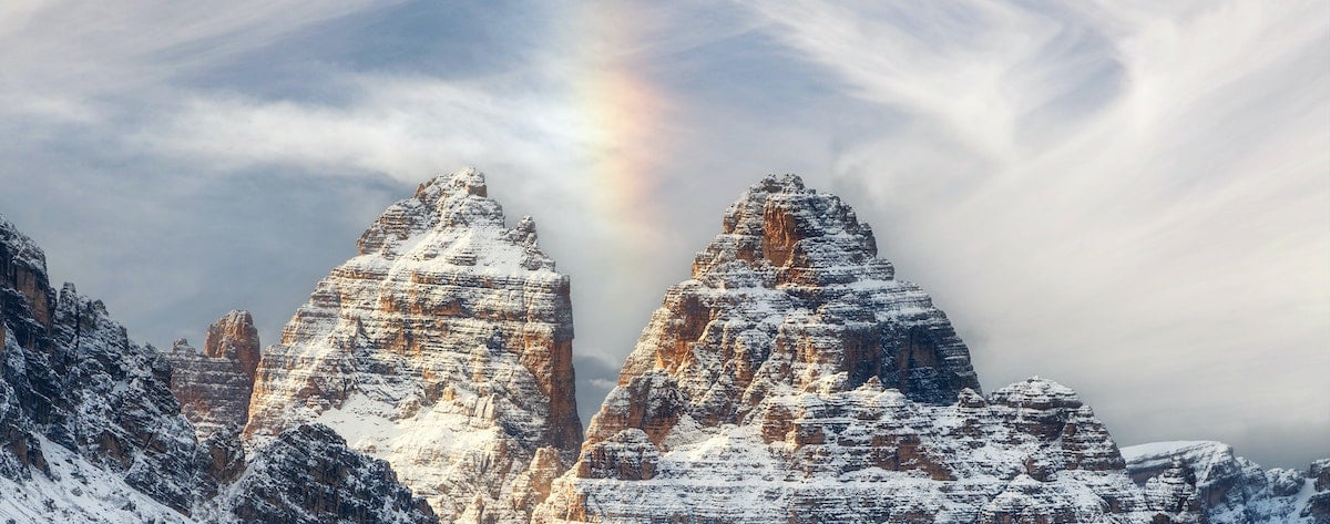 Single rainbow between two mountain peaks