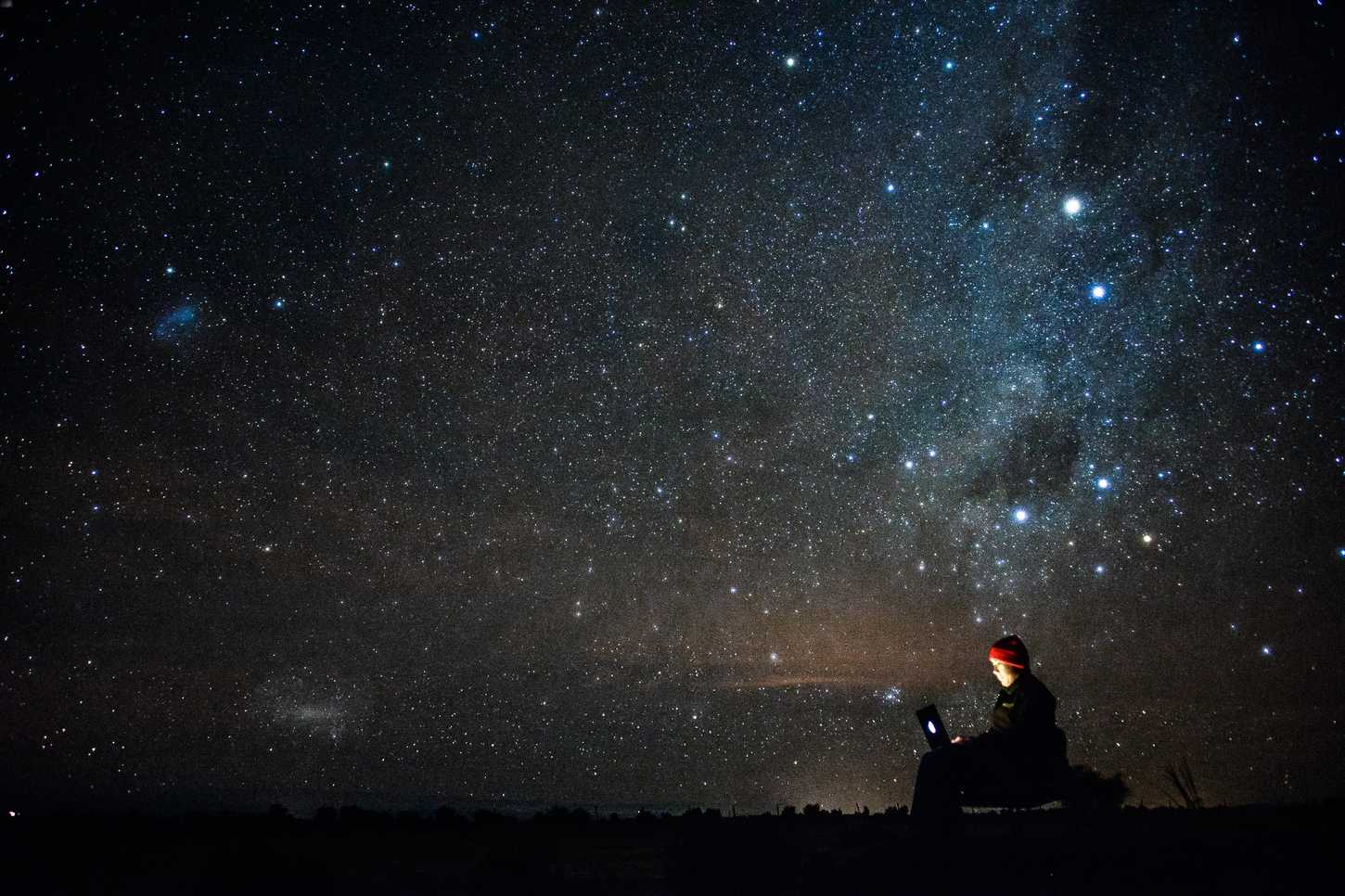 Person using laptop under a starry sky