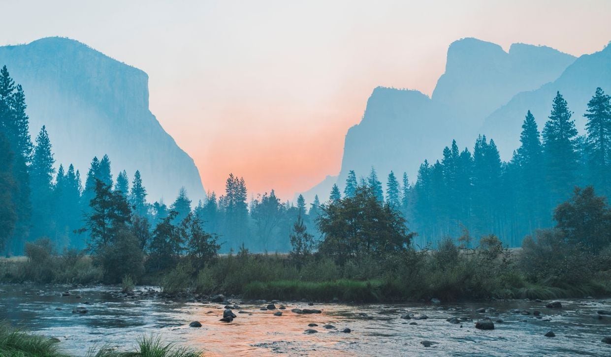 Foggy mountain landscape with a setting sun