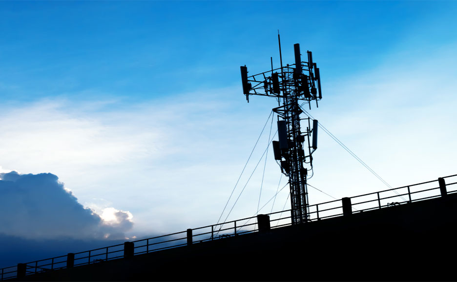 Mobilfunkmast vor blauem Himmel als Teil einer sicheren Kommunikationsinfrastruktur für moderne Verteidigungs- und Sicherheitsanwendungen