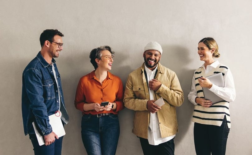 A smiling group of individuals standing closely together, showcasing camaraderie and happiness in a social gathering.