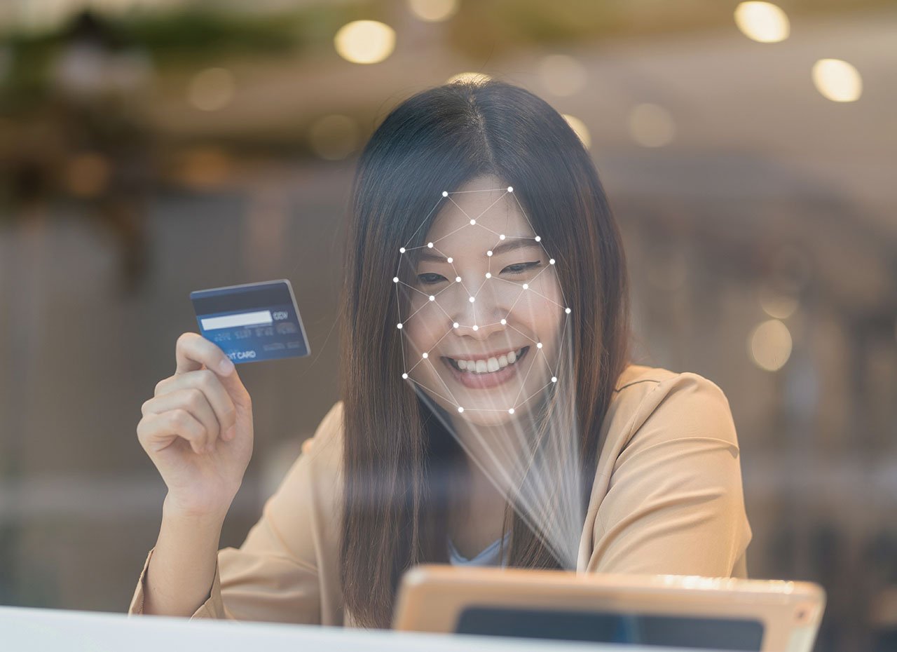 Asiatische Frau mit einem Tablet für Gesichtserkennung beim Einkaufen mit der Kreditkarte, Kreditkarten-Mockup, Online-Zahlungskonzept