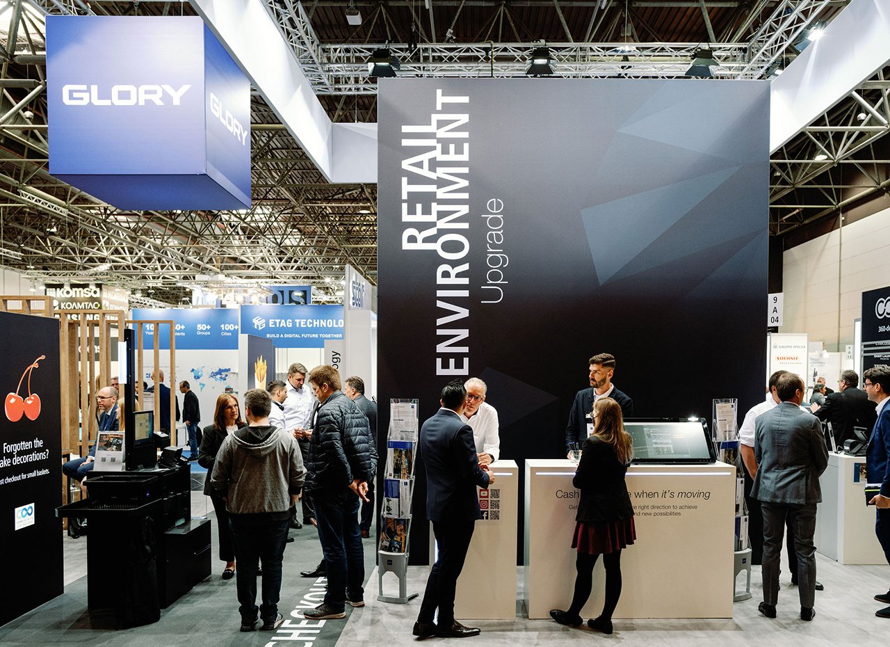 Personen stehen verteilt an einem Messestand