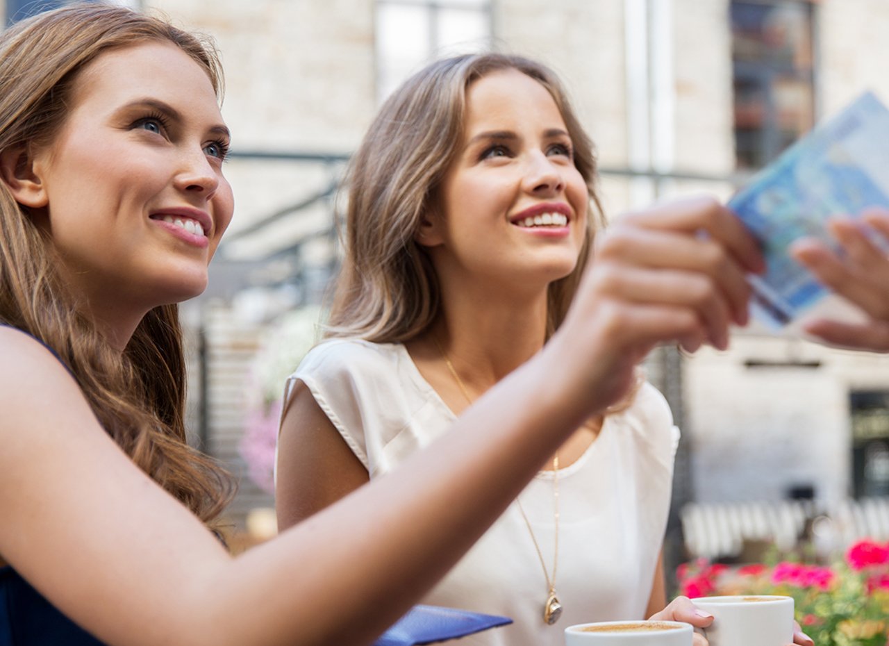 Zwei Frauen zahlen bar im Außencafé