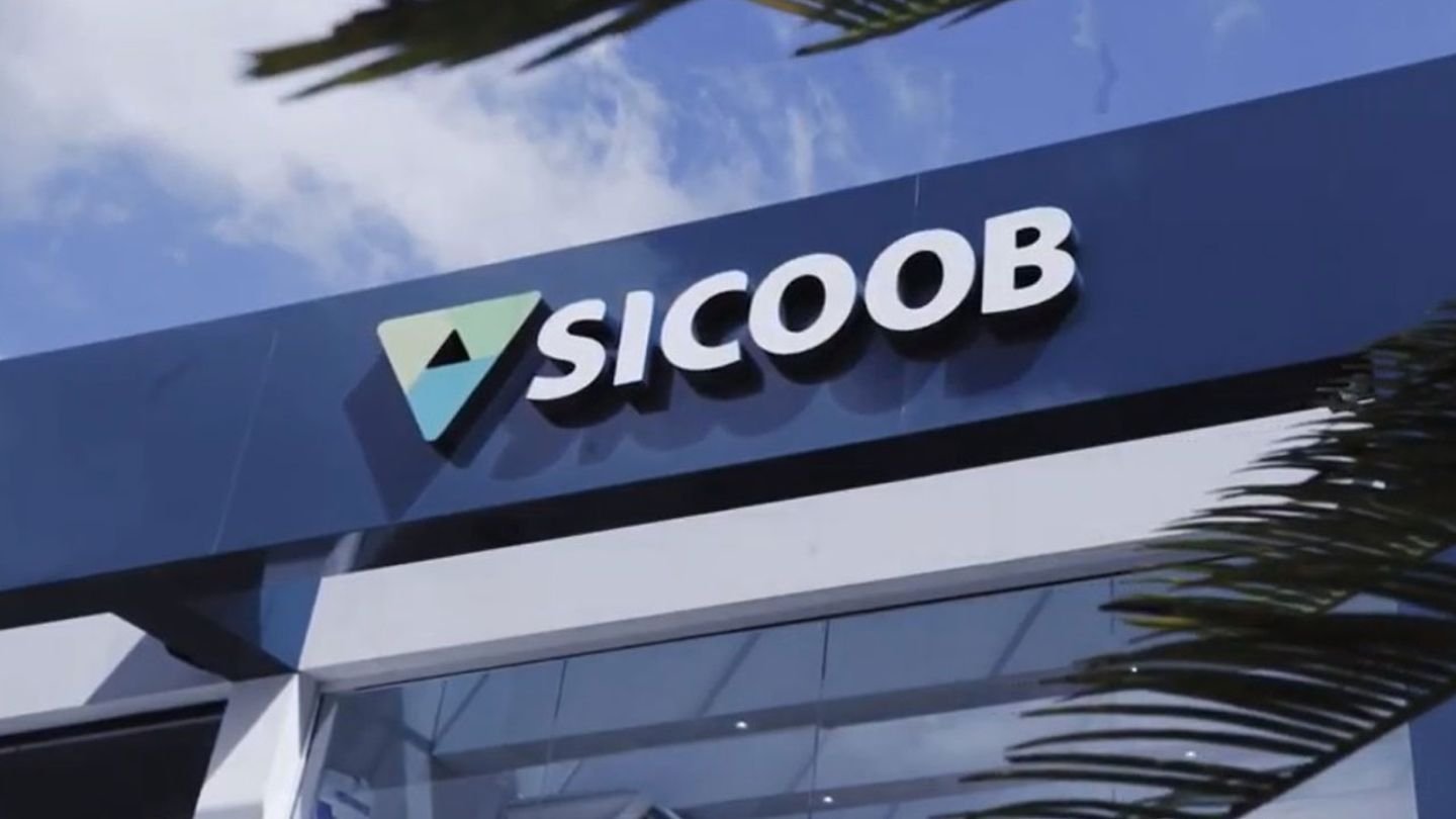 Fachada da agência Sicoob com o logotipo visível em um dia ensolarado, destacando a instituição financeira cooperativa.