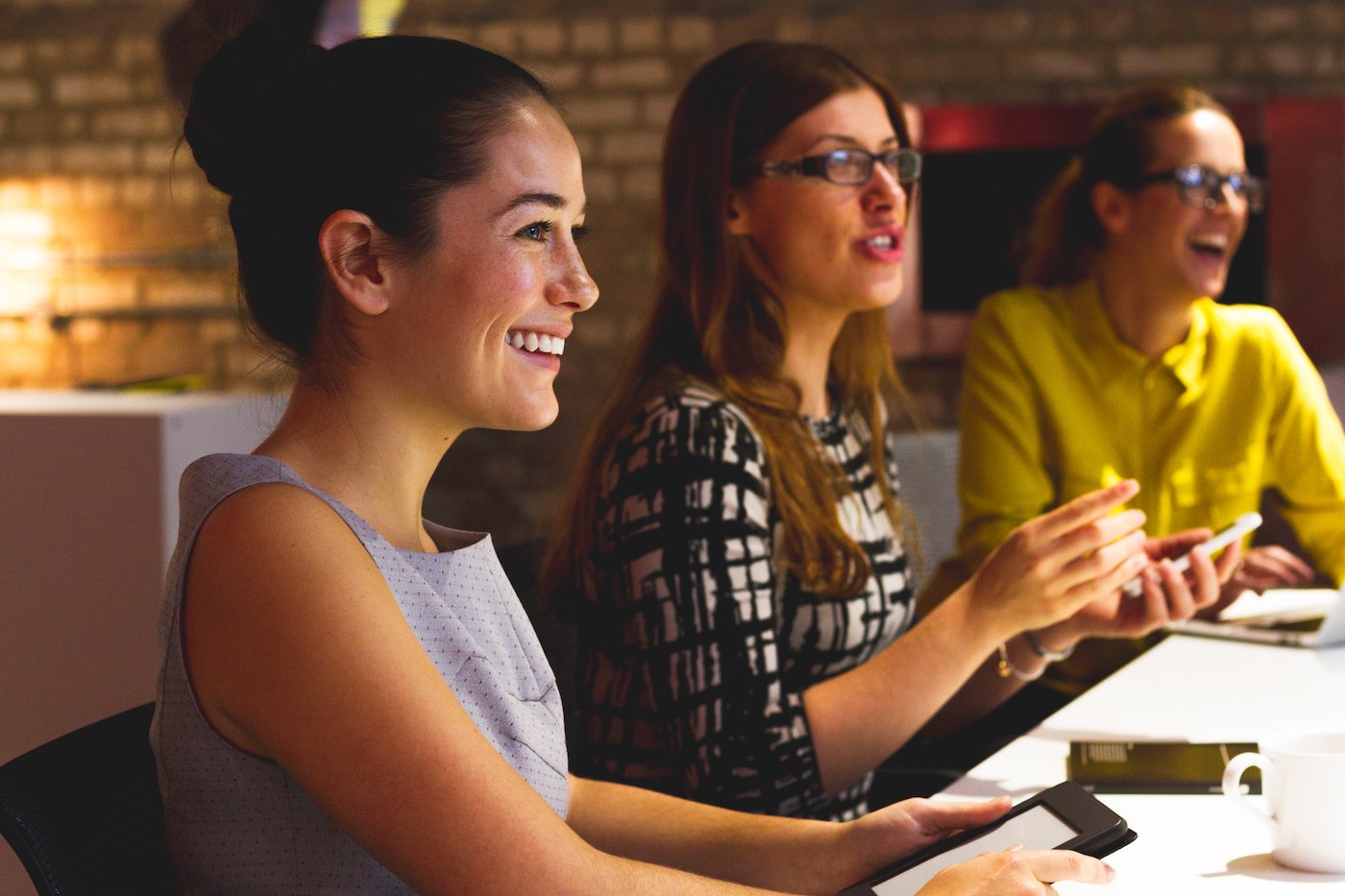 Three young women working together in a modern small business office