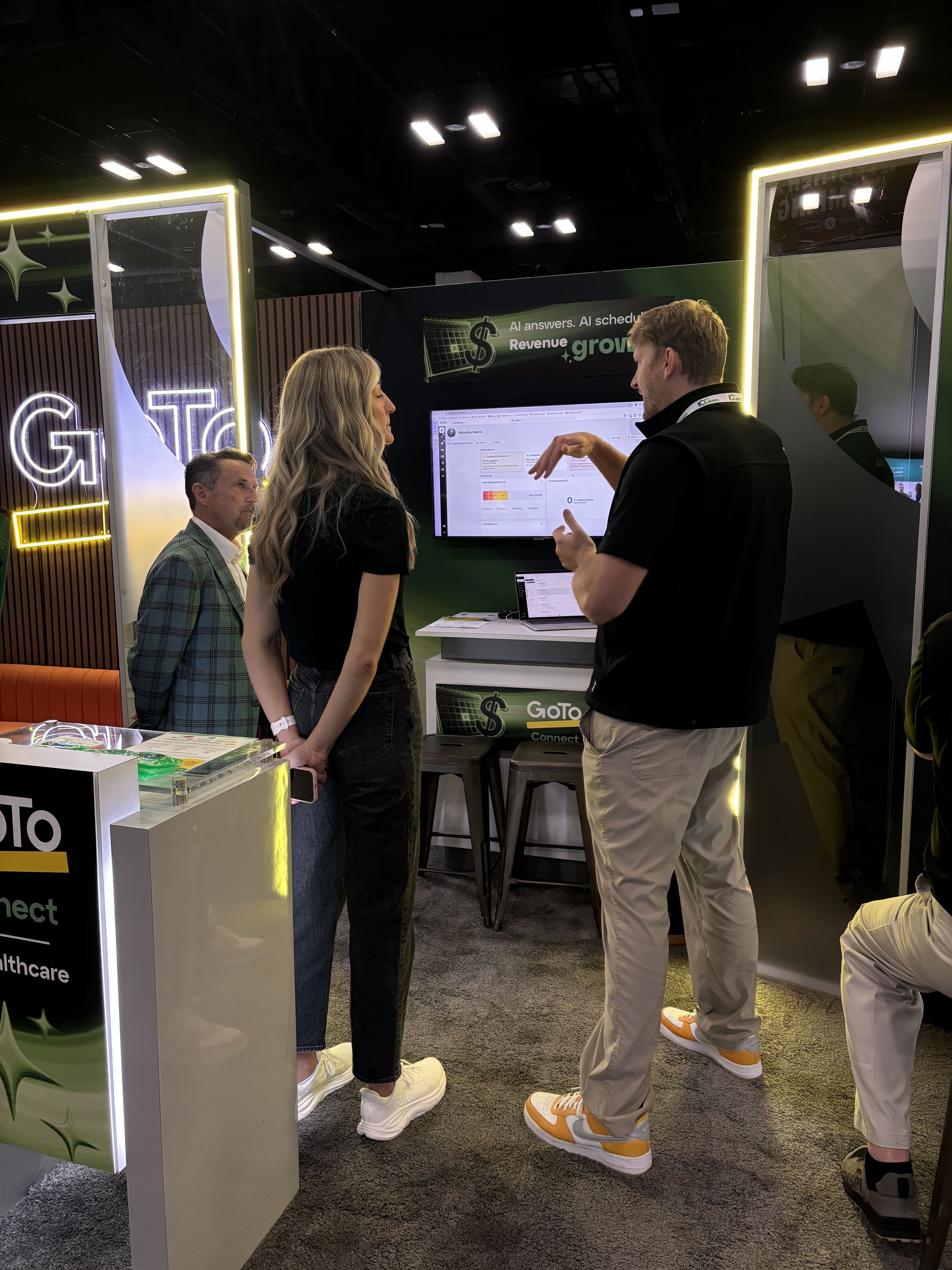 People standing at a computer listening to someone talk