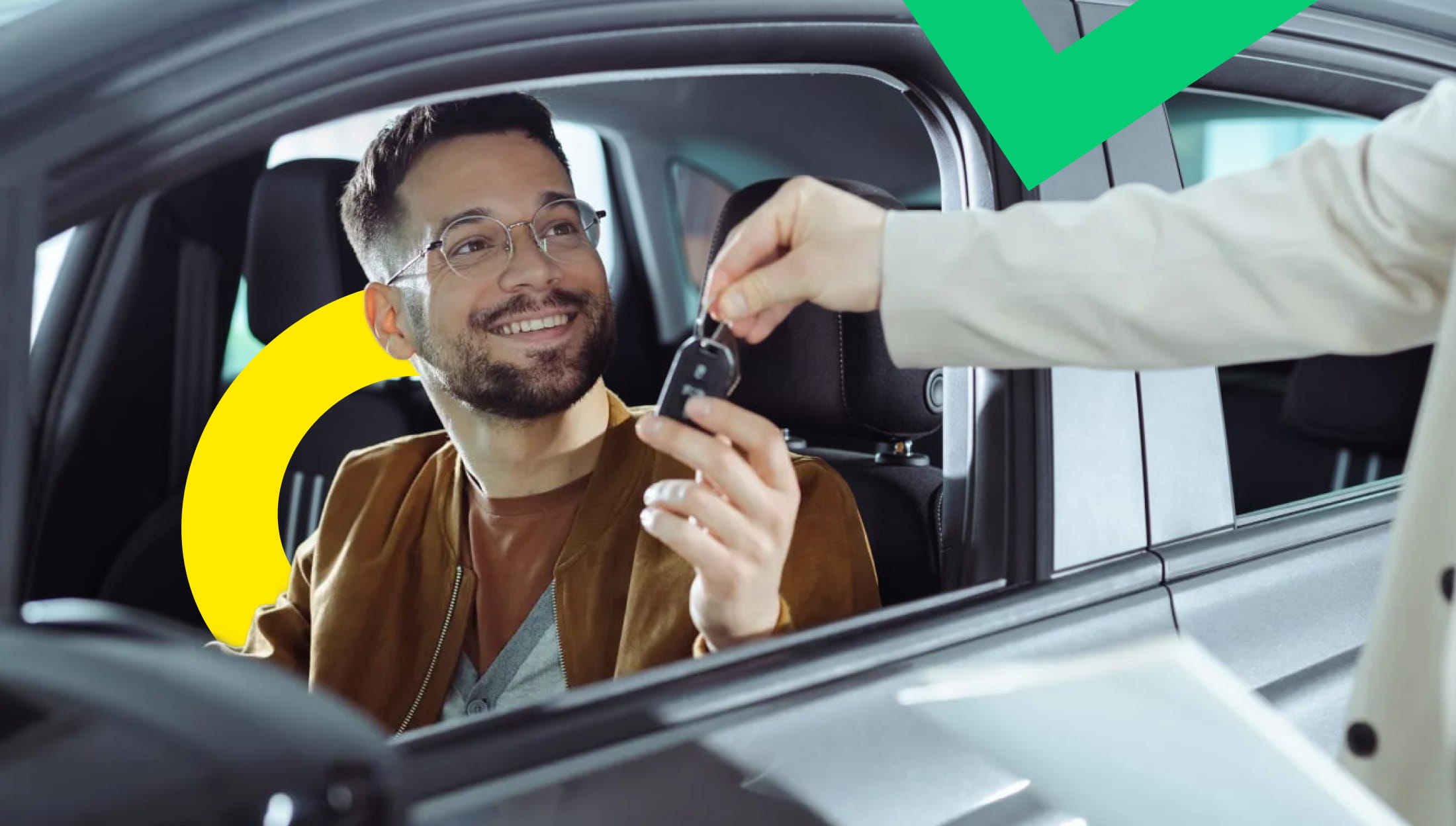 A happy customer receiving keys for his new car in an auto dealership showroom.