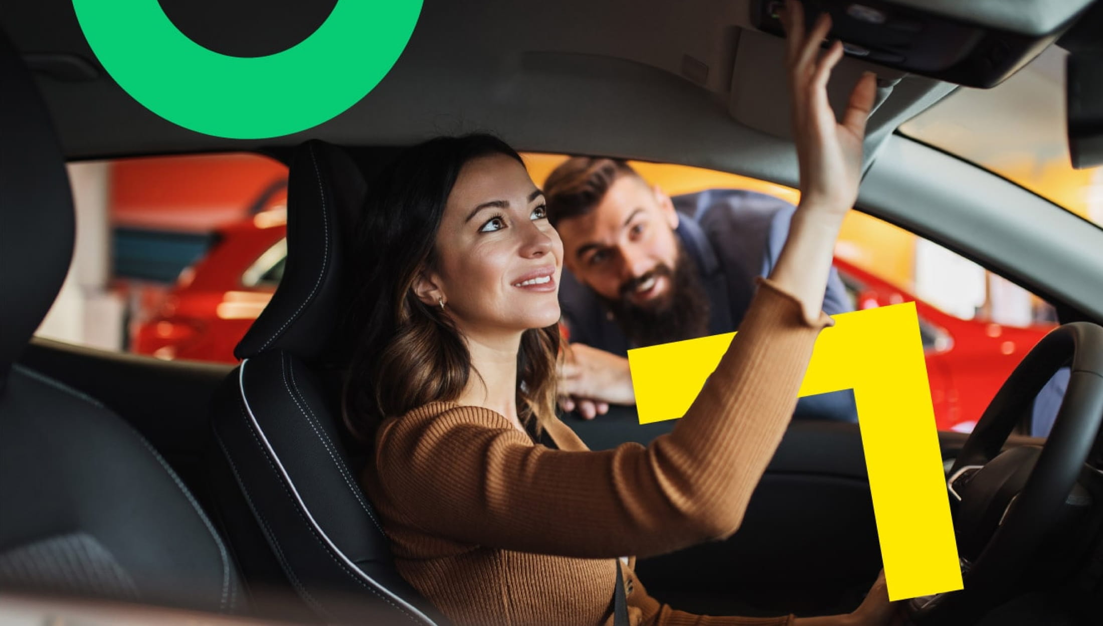 A person sits in the driver’s seat of a car, reaching up toward the overhead controls, with a sales associate outside the car window providing details on the vehicle's features.