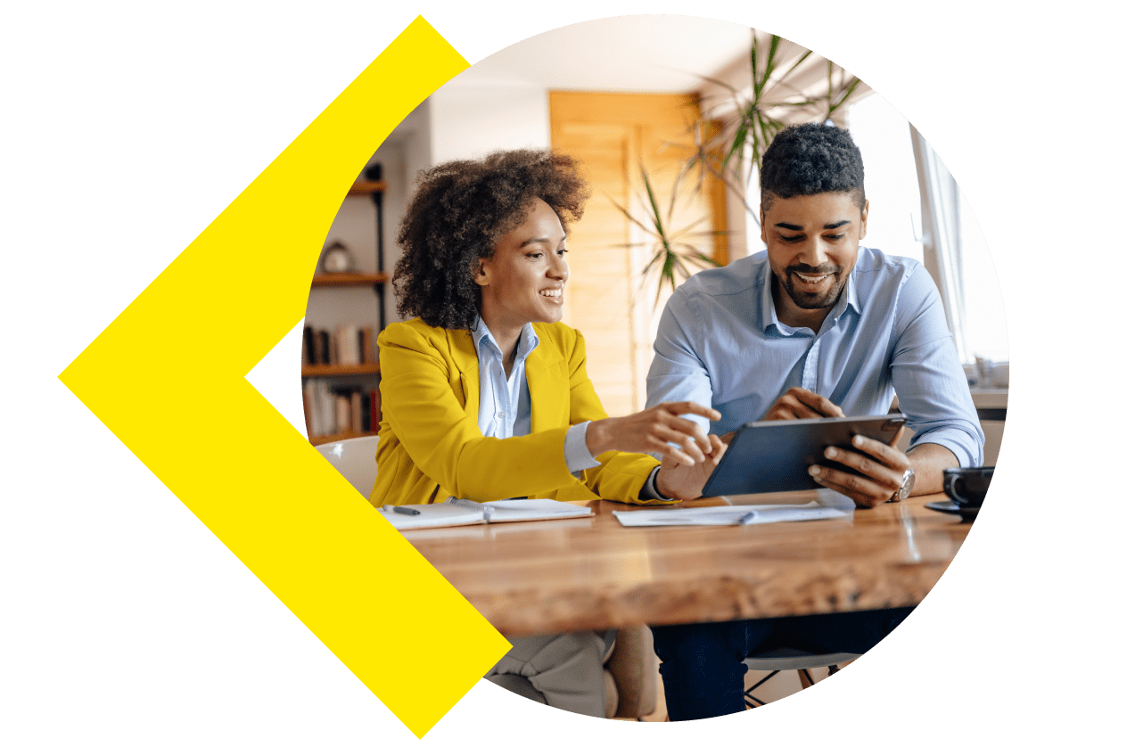 Two people smiling and interacting with a tablet.