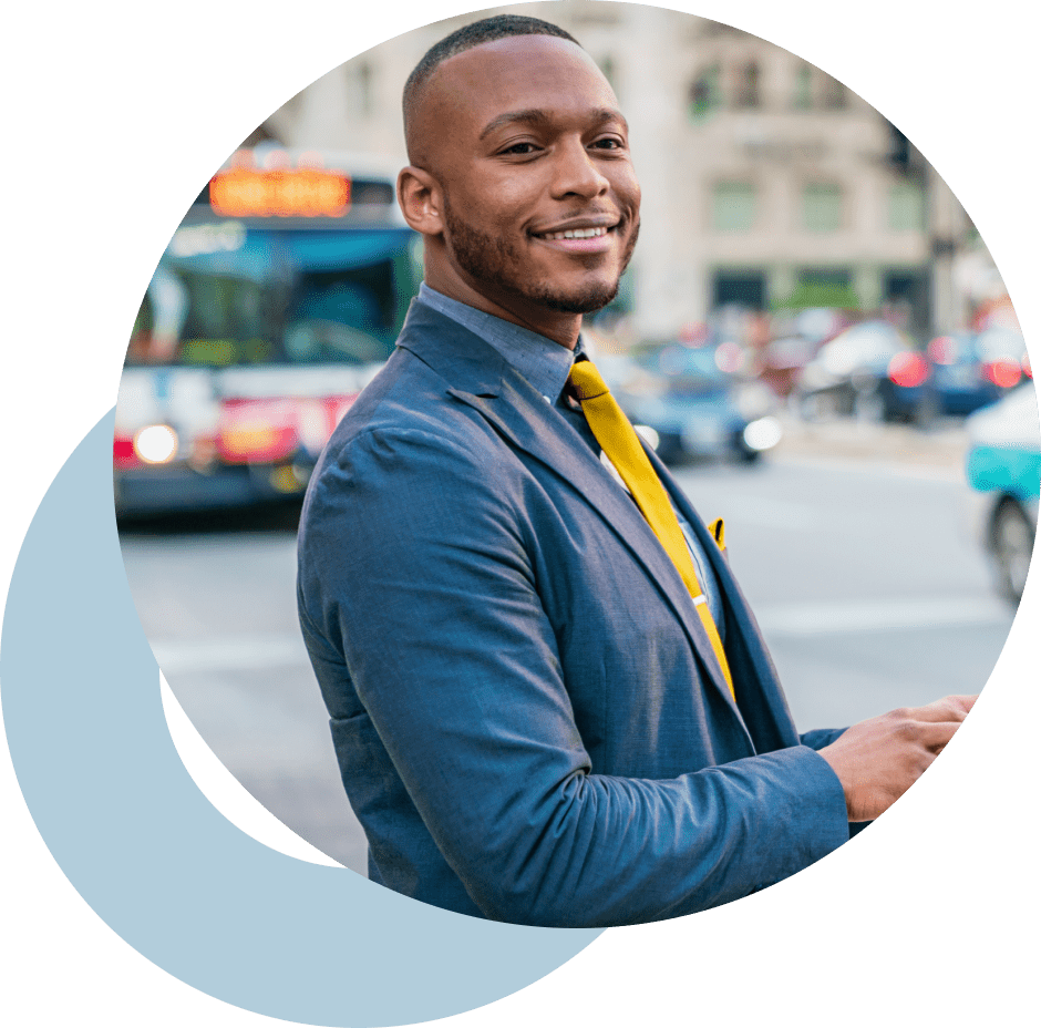 Business man in an urban setting smiling.