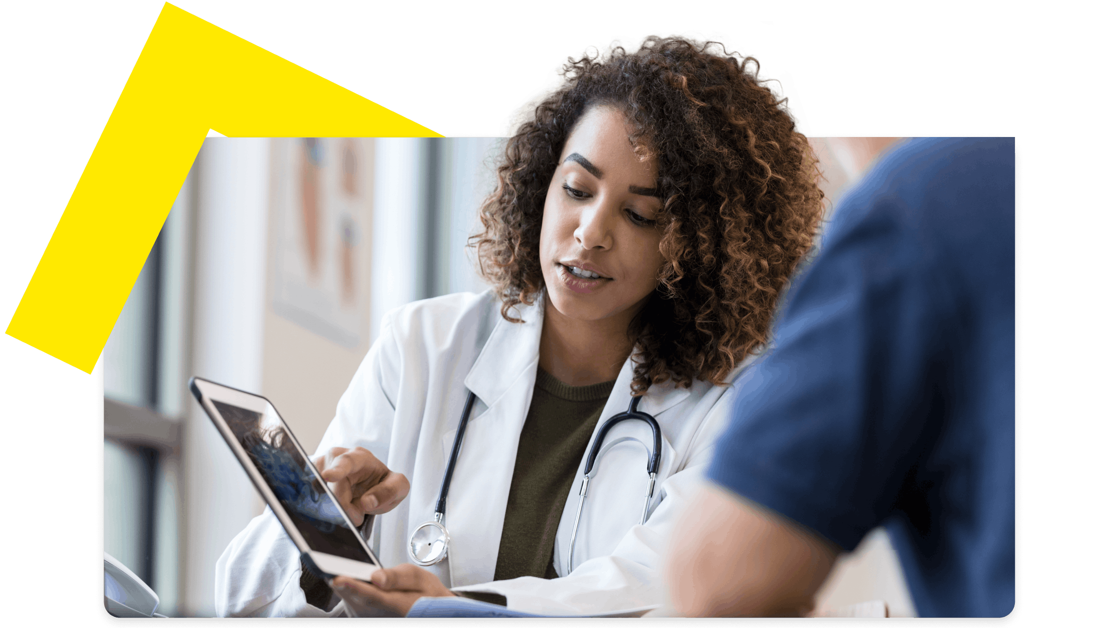 Healthcare provider discussing information on a tablet with a patient during an appointment.
