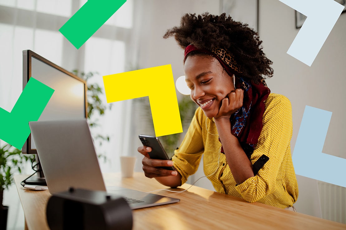 Woman using GoToConnect on her phone and laptop, from her home office. 