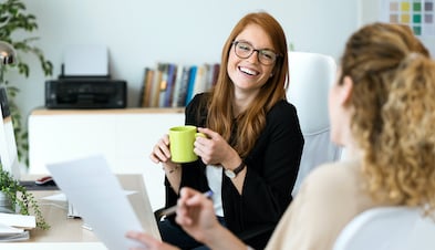 Laughing coworkers meeting and drinking coffee