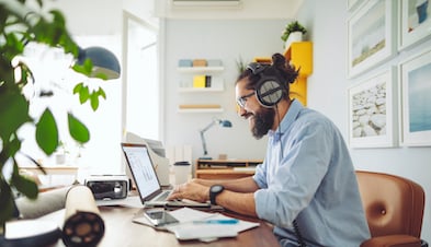 Remote employee with headphones working from home office