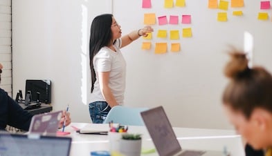 Team collaborating with sticky notes on whiteboard