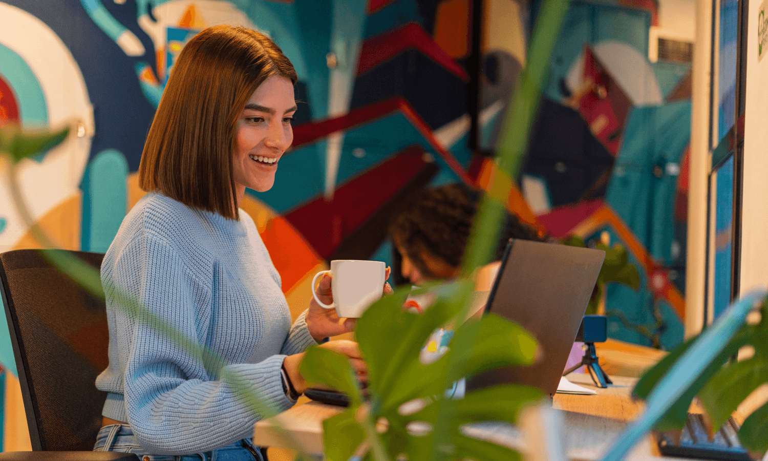 Mujer sonriente trabajando en un portátil.
