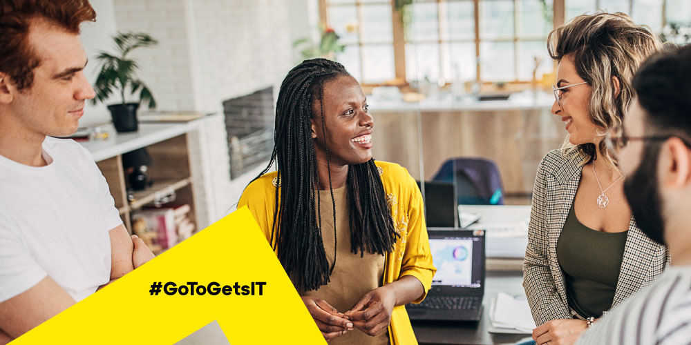 Group of coworkers gathered in a circle talking about how to improve IT workflows