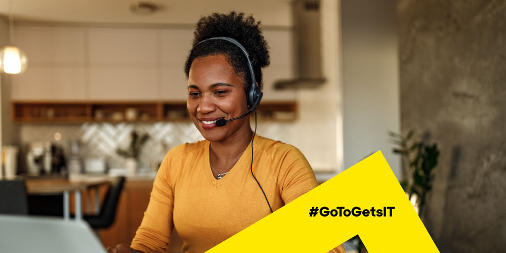 Mujer con auriculares y trabajando en un portátil en casa activando la automatización PowerShell con arquitectura de seguridad Zero Trust.