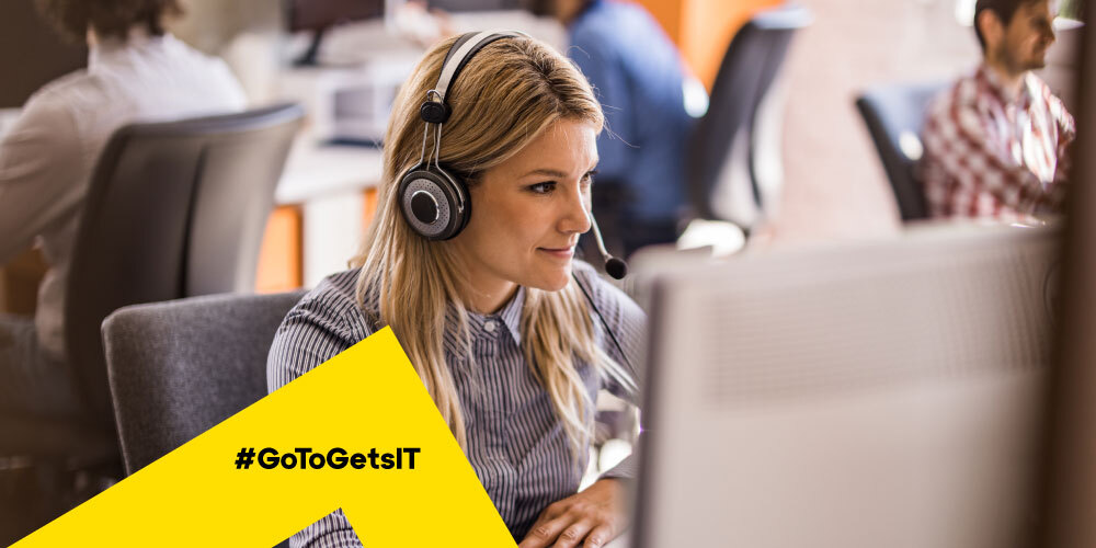 Agente de TI con auriculares trabajando en un sistema de asistencia técnica y utilizando el software de avisos y supervisión de servidores