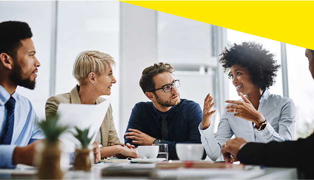 A group of professionals sitting together in a meeting discussing.