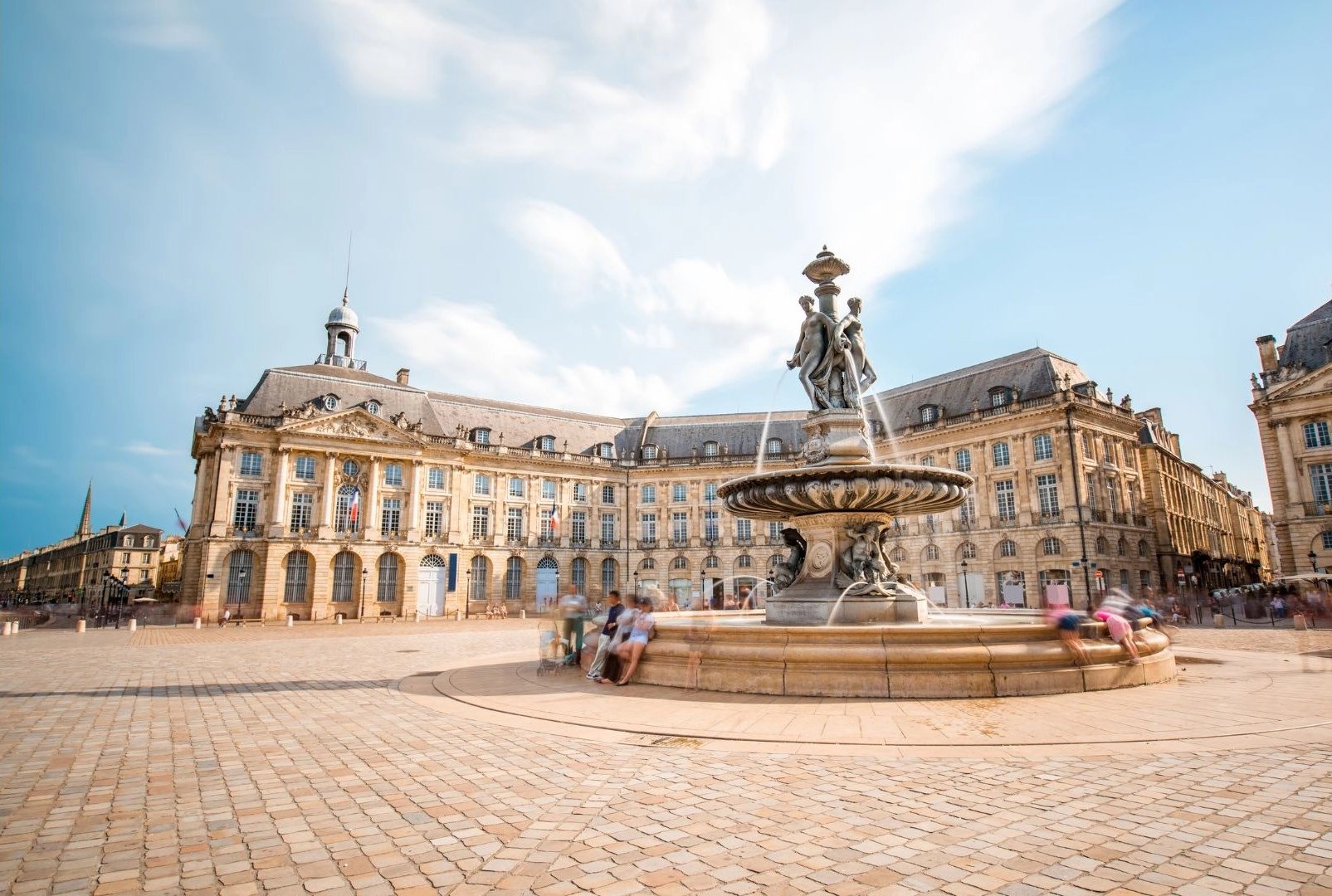a fountain in a courtyard with people walking around