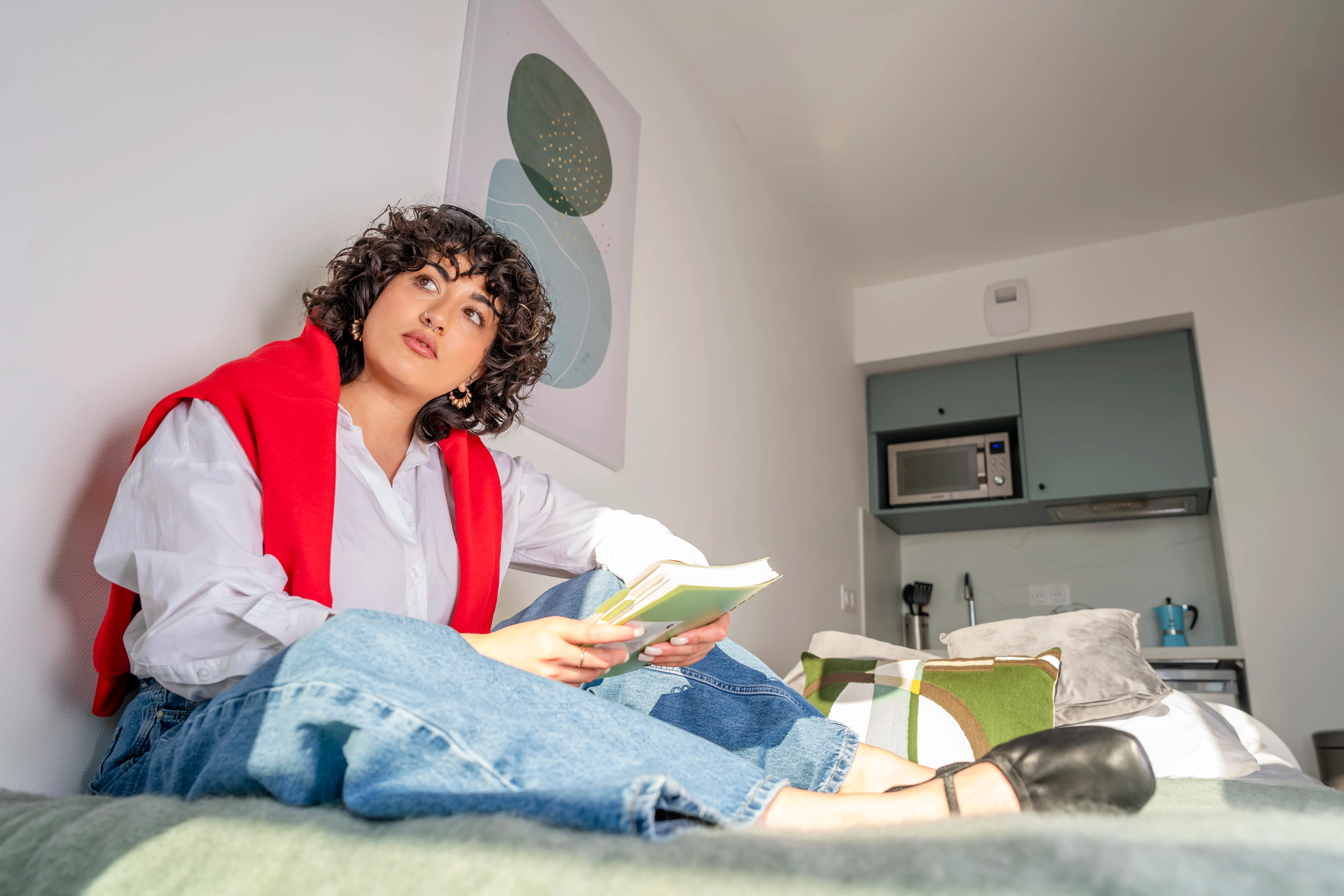 a woman sitting on a bed with a book