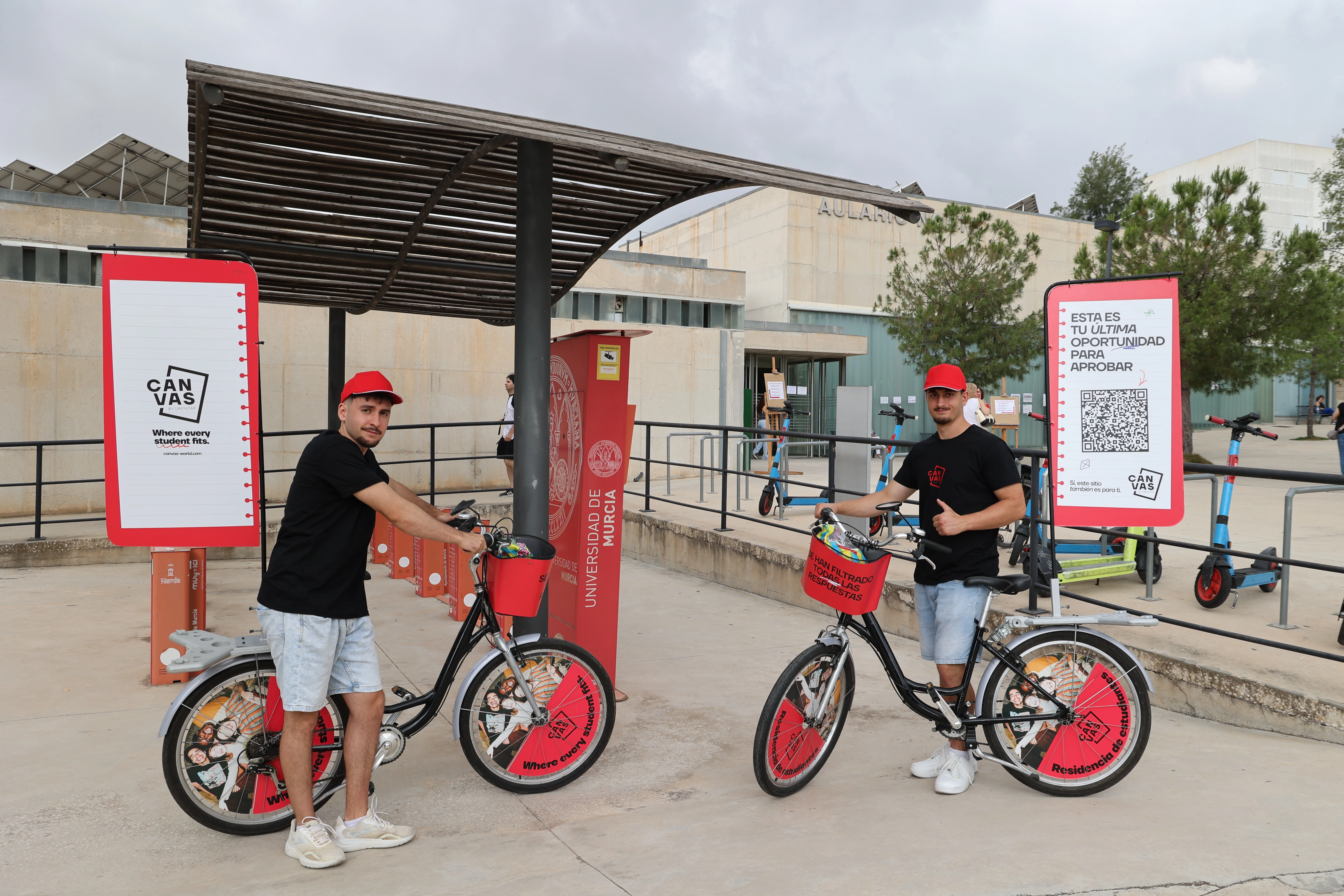 two men on bicycles next to a sign