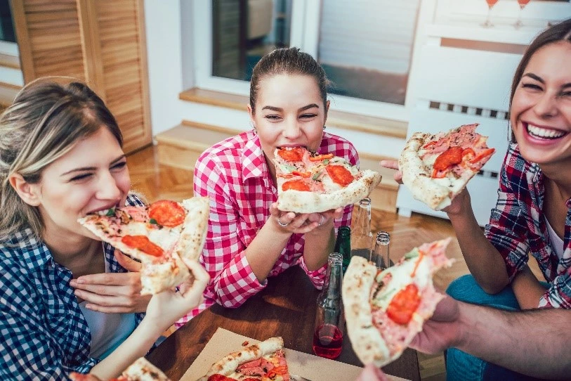 a group of people eating pizza