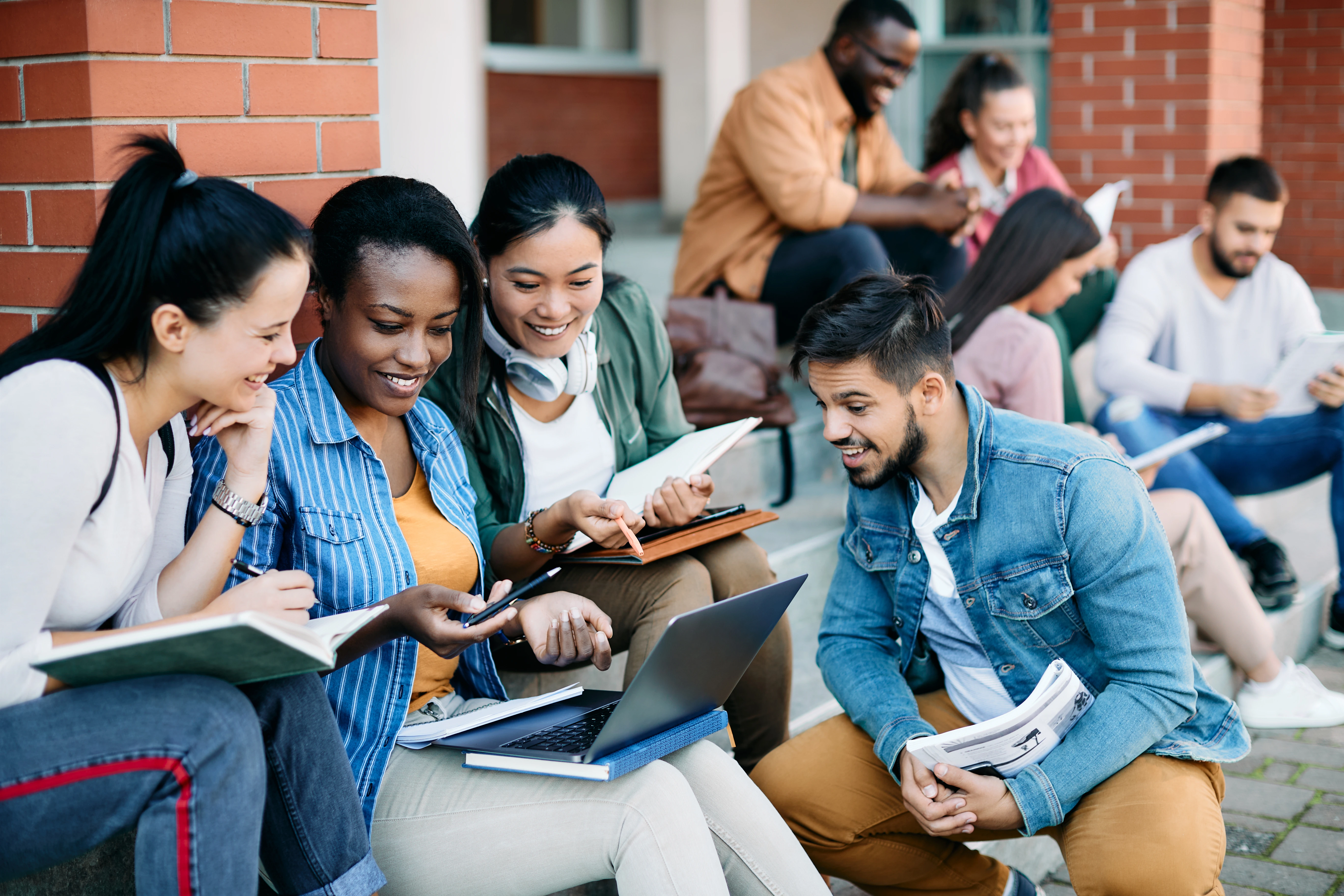 smiling students looking at a computer