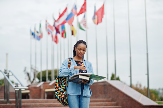 joven estudiante consultando libros en un campus universitario