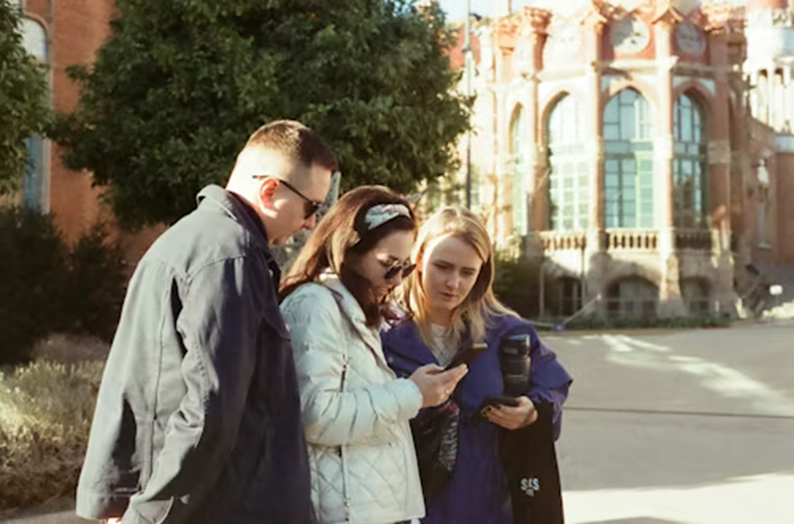 Group of international students consulting a map of the city in winter during a practical orientation tour.