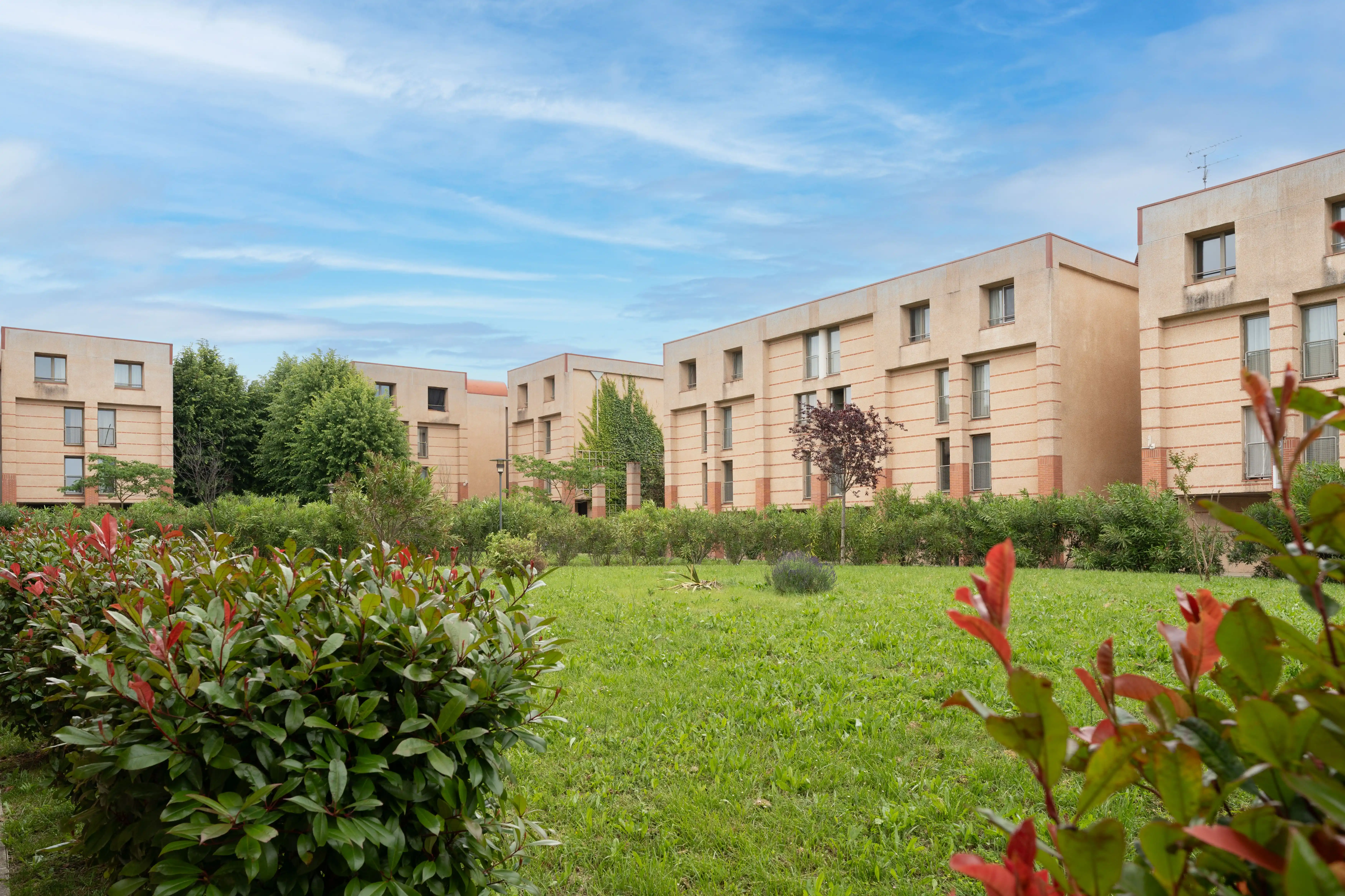 a building with a lawn and bushes