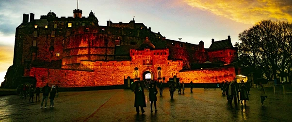 a group of people walking in front of a castle