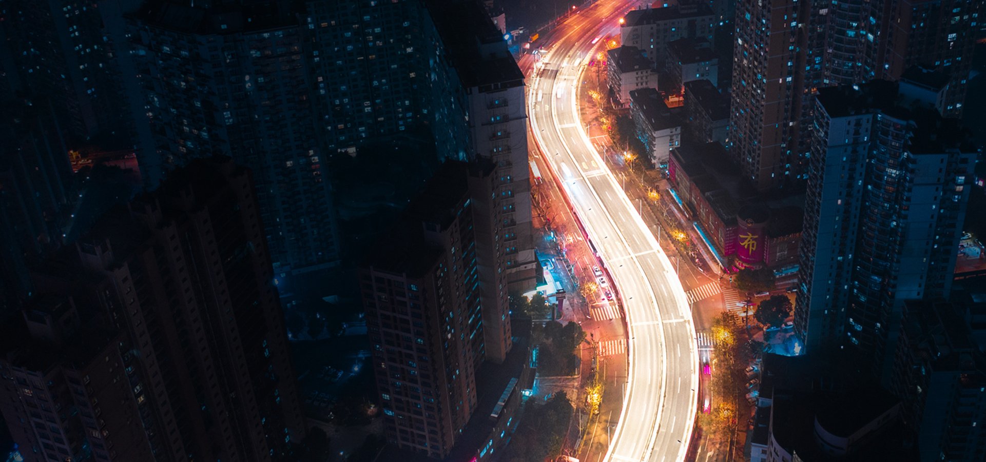 aerial view of nighttime lighted city street traversing a city
