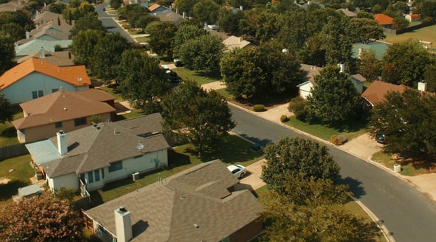 aerial shot of suburban homes on tree-lined street
