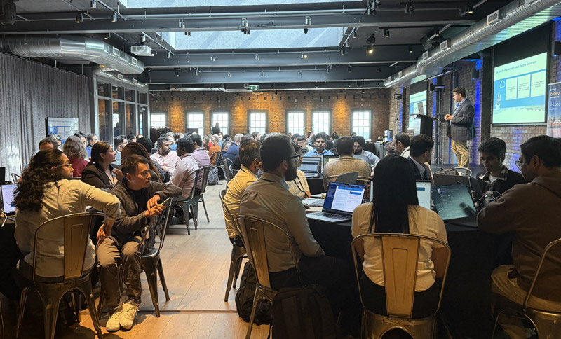 event room with group of attendees listening to a speaker