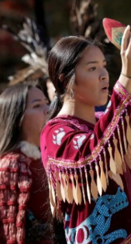 Person participating in cultural activity with traditional attire