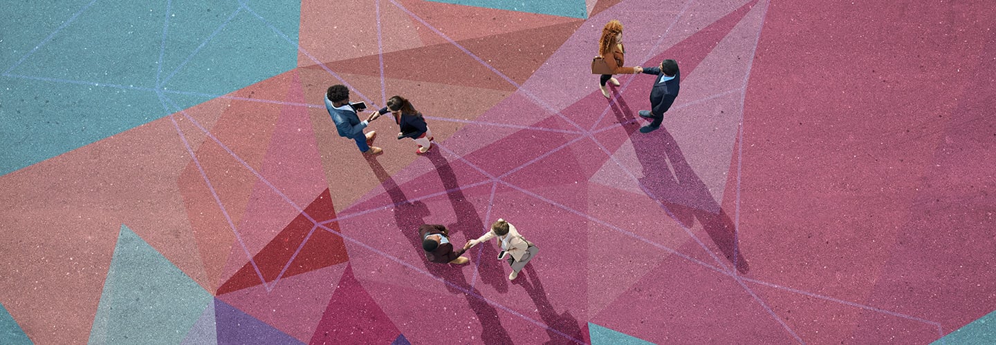 Overhead view of people shaking hands standing on a colorful concrete patio