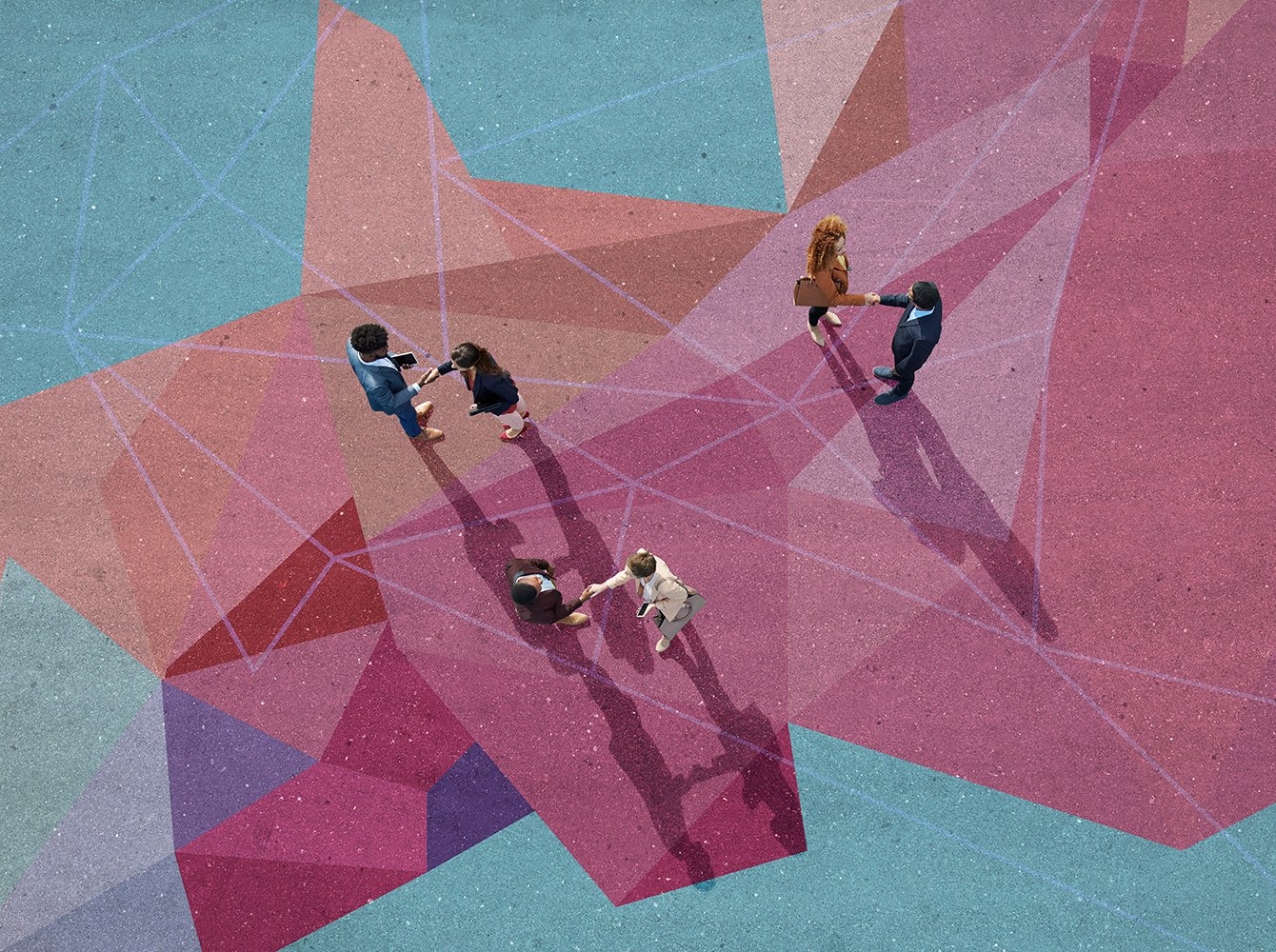 Overhead view of people shaking hands standing on a colorful concrete patio