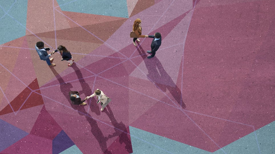 Overhead view of people shaking hands standing on a colorful concrete patio