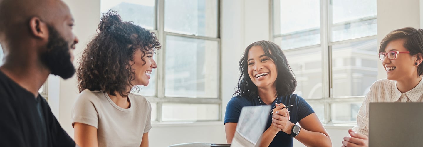 four coworkers smiling during a meeting