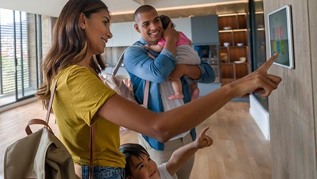 Woman and man with children looking at smart home feature